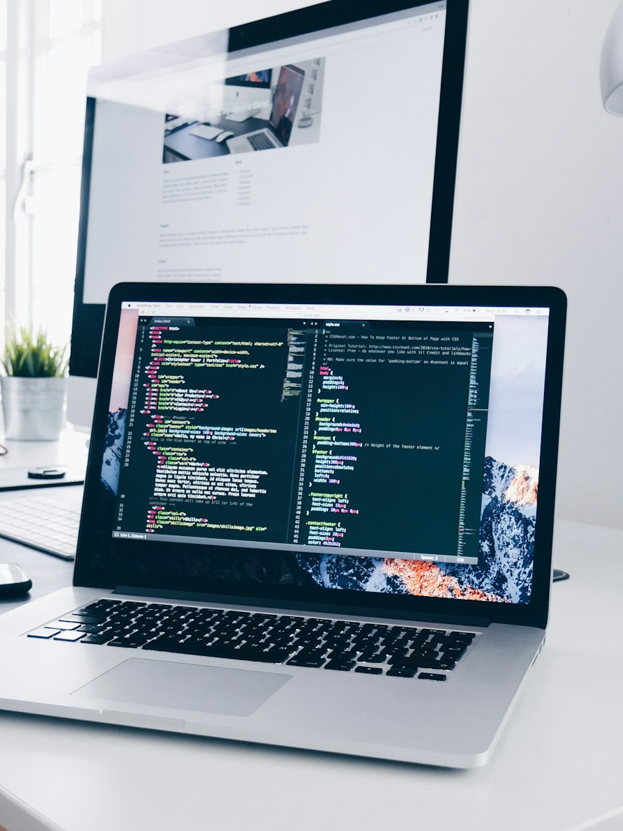 Estação de trabalho com código em tela, representando desenvolvimento web
